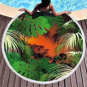 Circular tropical plant beach towel with white tassels and palm leaves design