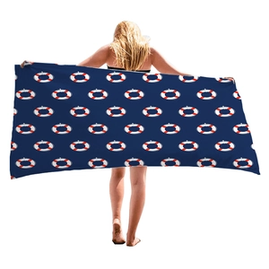 Navy blue beach towel with anchor and lifebuoy patterns held by a female model