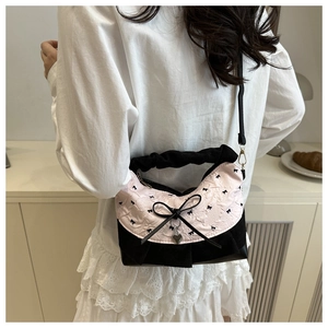 Detail of Korean style pleated bag featuring black ribbon bow and silver heart pendant