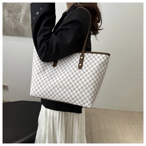 Close-up of brown leather shoulder strap and vintage geometric pattern on large tote bag