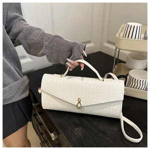 Détail du sac à main blanc à texture crocodile avec fermoir infini doré et poignée
