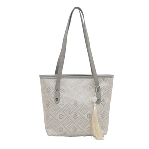 Borsa tote beige capiente con ricamo geometrico e ciondolo a nappa decorativa