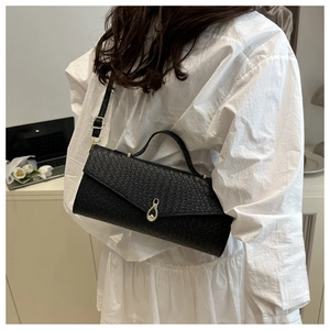 Close-up of black crocodile pattern leather texture with golden teardrop metal clasp