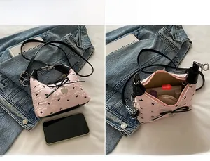 Close-up of pink quilted mini bag showing the main compartment and heart pendant