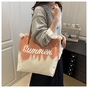 Detail of coral pink and beige canvas tote with fringe trim and Summer print on side