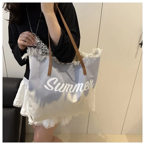 Détail du sac cabas en toile avec imprimé Summer, bords effilochés et anses en cuir brun