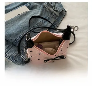 Pink ballet style crossbody bag capacity detail with ribbons and internal essentials