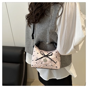 Detail of pink balletcore shoulder bag with black rabbit embroidery and bow accent