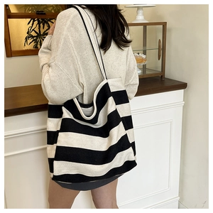 Close-up of durable black and white striped canvas tote bag with wide shoulder strap