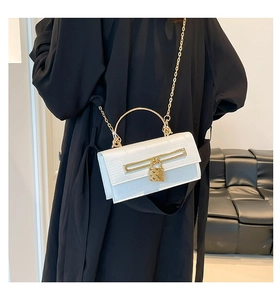Detailaufnahme der weißen Mini-Kelly-Tasche mit Krokodilprägung und goldenem Herzschloss