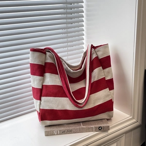 Striped canvas tote bag in red and white with wide shoulder straps on window sill