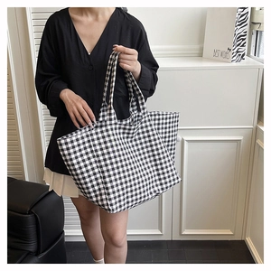 Detail of checkered canvas tote bag with black and white gingham pattern and sturdy handle