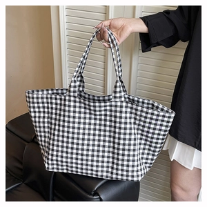 Close-up of checkered canvas tote bag showing the large capacity and durable black-white pattern