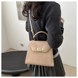 Detail of light khaki leather trapezoid bag with gold square lock and top handle