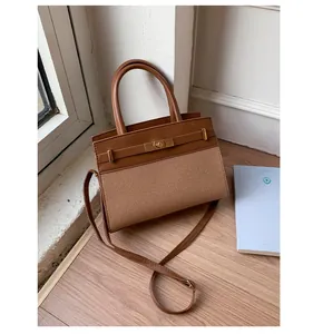 Detailed shot of brown contrast stitching PU handbag with woven texture and metal clasp