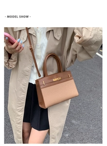 Outdoor model wearing a beige canvas and brown leather Kelly-style bag with gold buckle