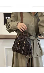 Vue détaillée du mini sac à dos marron avec imprimé monogramme ours et zips verticaux