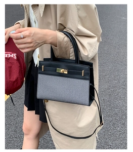 Close-up of stylish leather and fabric patchwork crossbody bag with gold turn-lock