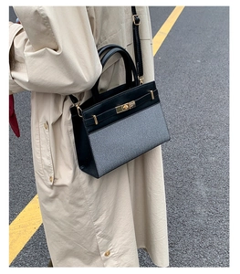 Detail of a contrasting patchwork shoulder bag with gold twist lock on a beige trench coat