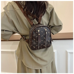 Brown mini leather backpack with cute bear print shown on back to display the compact size
