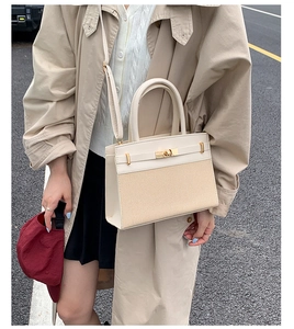 Detail of a beige patchwork crossbody bag with gold metallic lock and shoulder strap