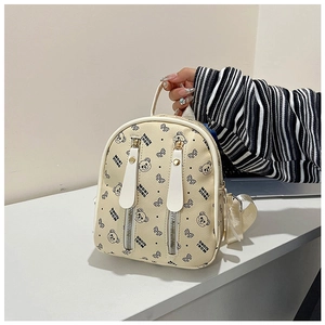 Détail d'un mini sac à dos beige en cuir PU avec motifs d'ours et double fermeture éclair