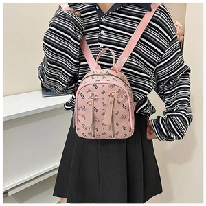 Detail of pink backpack with bear prints and metallic zipper pockets on faux leather