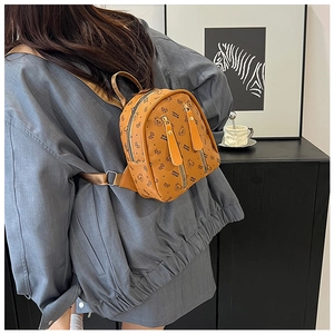 Mini sac à dos marron à motifs d'ours porté par un mannequin dans un décor moderne