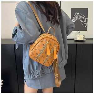 Vue détaillée d'un mini sac à dos marron avec motif ours porté par un mannequin
