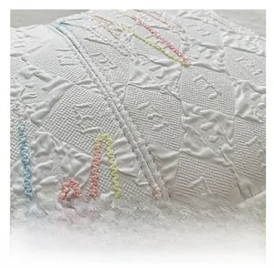 Detailed close-up of white embossed tote bag with 3D letter texture and colorful stitching