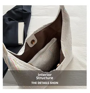 Internal view of cream tote bag featuring brown lining, zipper pocket and magnetic buckle