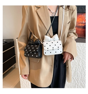 Close-up of cute polka dot mini crossbody bags with decorative 3D bows and slim straps