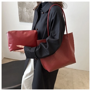 Detail of burgundy woven tote bag with matching inner pouch shown on a model