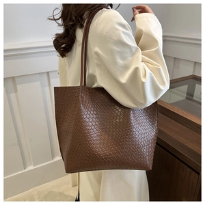 Detail of deep brown leather tote with woven pattern and stylish long shoulder straps