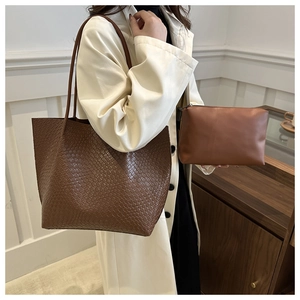 Close-up of brown woven texture tote bag and matching leather pouch for women
