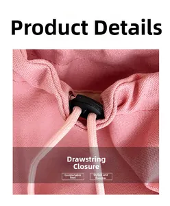 Detail of pink canvas tote bag showing black plastic drawstring closure and woven rope