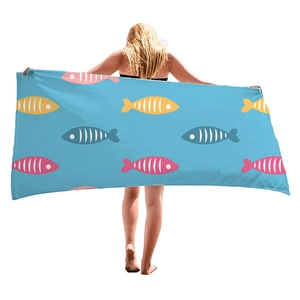 Hellblaues Mikrofaser-Strandtuch mit bunten Fischmustern, getragen von einem Modell
