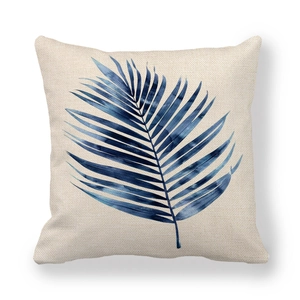 Square linen pillow cover featuring blue watercolor palm leaves on a beige background