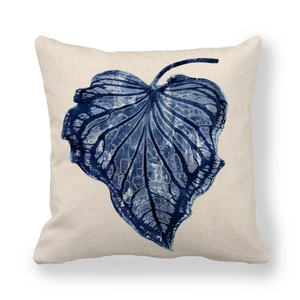 Detailed texture of blue ink palm leaf print on a beige linen throw pillow case