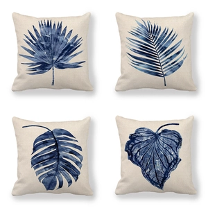 Set of four linen pillow covers featuring blue tropical palm leaf and monstera prints