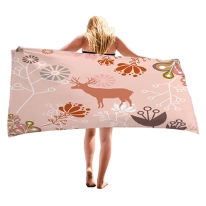 Pink bohemian beach towel with reindeer silhouette and geometric floral patterns
