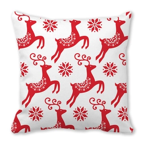 Detailed view of Christmas reindeer and snowflake prints on a soft white cushion cover