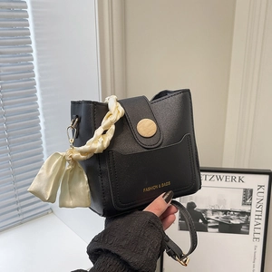 Minimalist black bucket bag with silk scarf handle and wooden buckle decoration