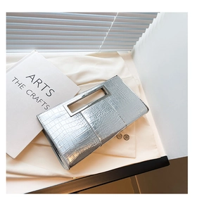 Detailed view of silver crocodile embossed envelope clutch with hollow metal handle