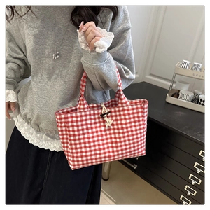 Détail du sac fourre-tout en toile à carreaux rouge et blanc avec fermeture à bascule