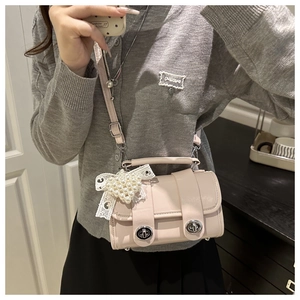 Détail du sac bandoulière rose avec dentelle et perles porté par un mannequin