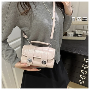 Détail du sac à main rose perle avec double fermoirs rotatifs argentés et poignée
