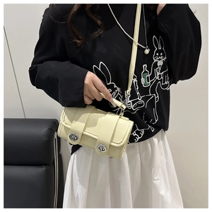Détail du sac à main rectangulaire jaune crème avec finition brillante et fermoirs