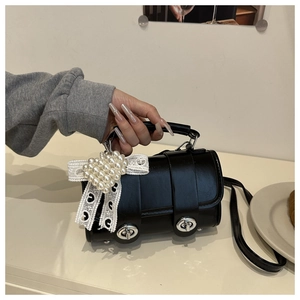Détail du sac polochon noir avec charm cœur en perles et dentelle romantique