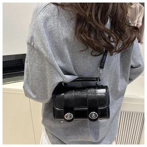 Gros plan d'un sac oreiller noir brillant avec fermoirs rotatifs en métal argenté